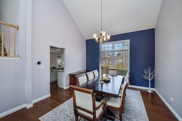 dining area featuring high vaulted ceiling, dark hardwood / wood-style floors, and a notable chandelier