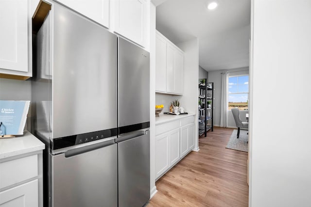 kitchen featuring white cabinetry, light wood-type flooring, and stainless steel refrigerator