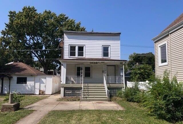 view of front of house with covered porch and a front yard