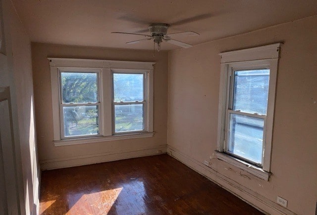 empty room with dark wood-type flooring and ceiling fan