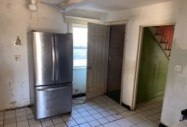 kitchen with light tile patterned flooring and stainless steel refrigerator