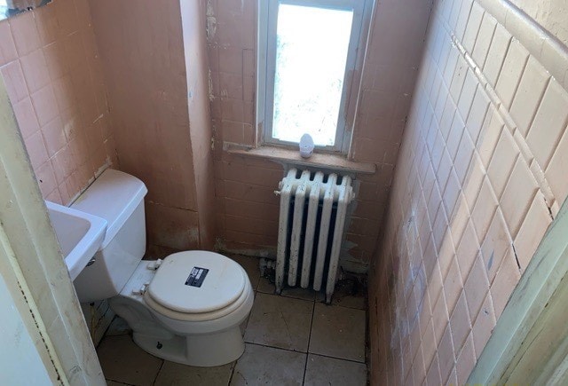 bathroom with tile walls, tile patterned flooring, toilet, and radiator