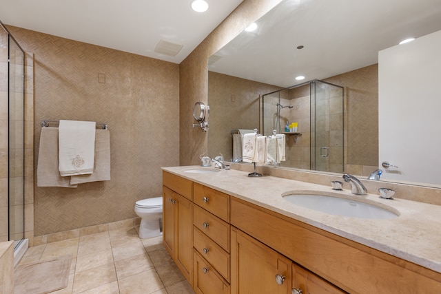 bathroom with tile patterned flooring, vanity, toilet, and a shower with door