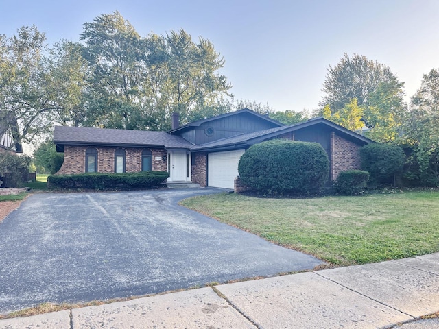 ranch-style house featuring a front yard and a garage