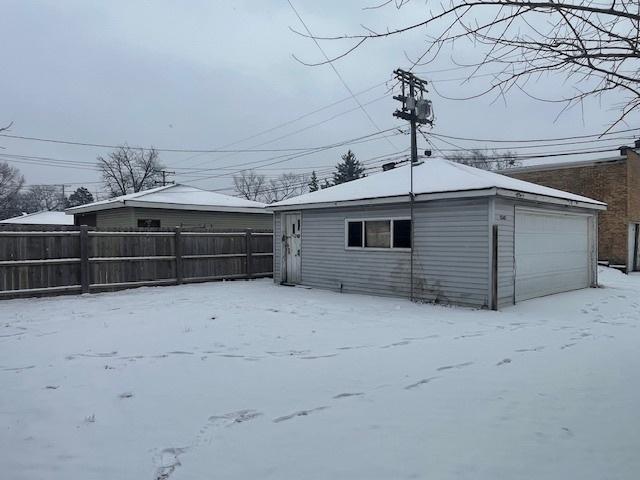 snow covered house featuring a garage