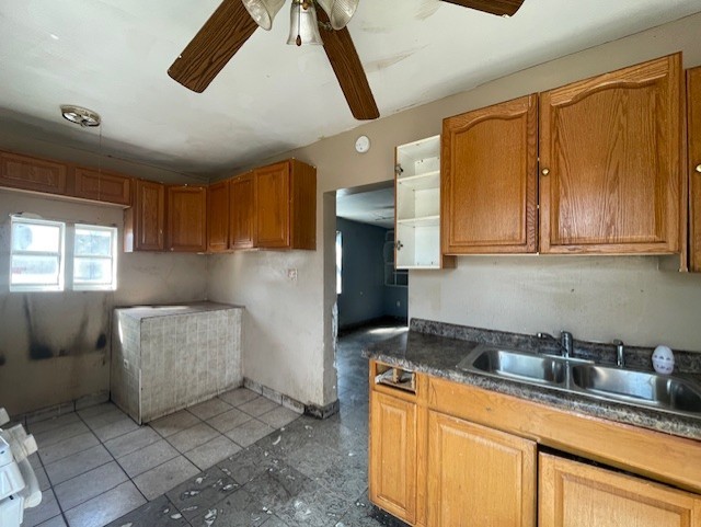 kitchen featuring dark tile patterned floors, sink, and ceiling fan