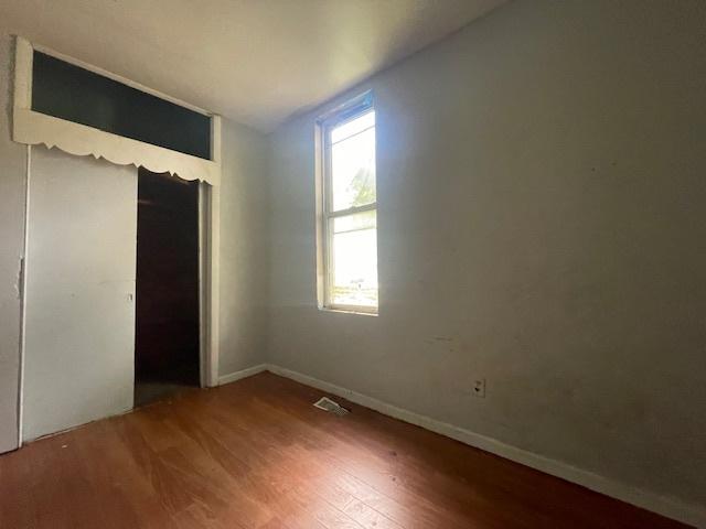 unfurnished bedroom with hardwood / wood-style flooring and a closet