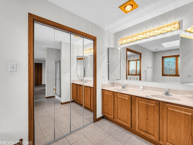 bathroom featuring tile patterned flooring, vanity, and a skylight