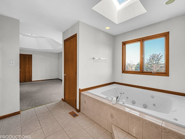 bathroom featuring tiled bath, tile patterned floors, and a skylight