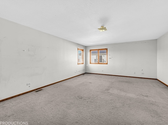 carpeted spare room with a textured ceiling