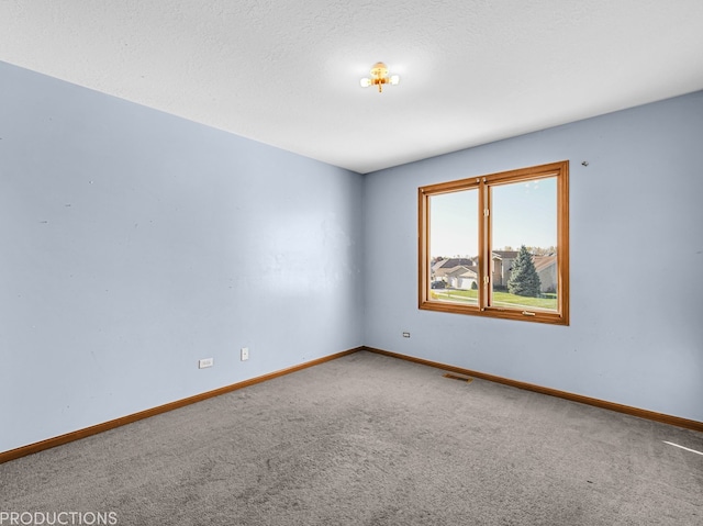 carpeted empty room with a textured ceiling