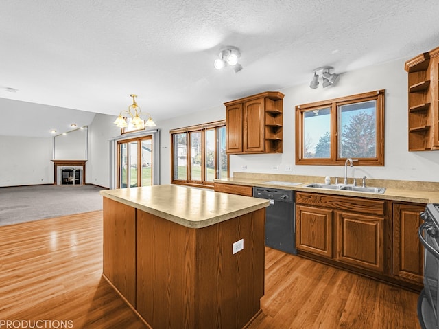 kitchen with dishwasher, sink, light hardwood / wood-style floors, a fireplace, and a kitchen island