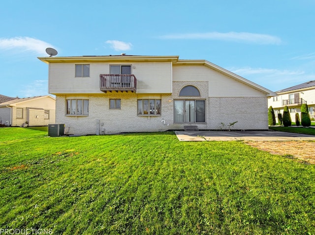 rear view of house with a lawn, central AC, a balcony, and a patio