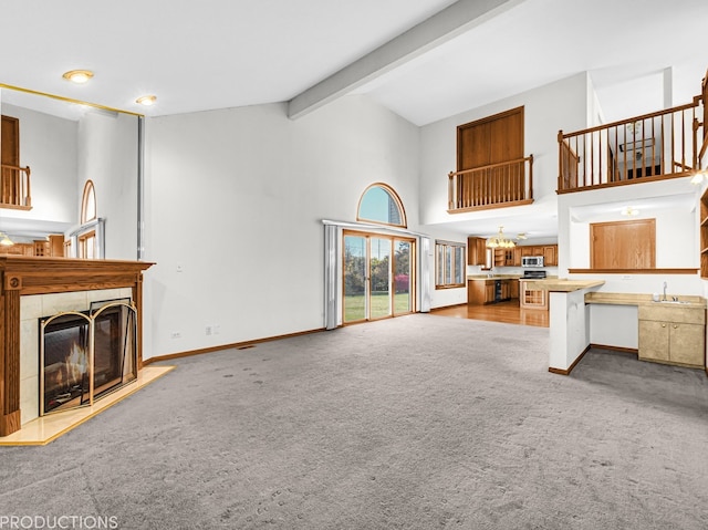 unfurnished living room with a tile fireplace, light colored carpet, high vaulted ceiling, and beamed ceiling