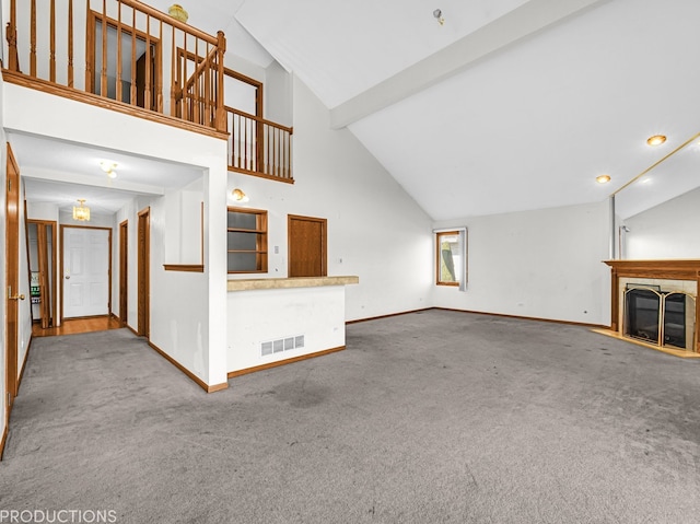 unfurnished living room featuring carpet floors and high vaulted ceiling