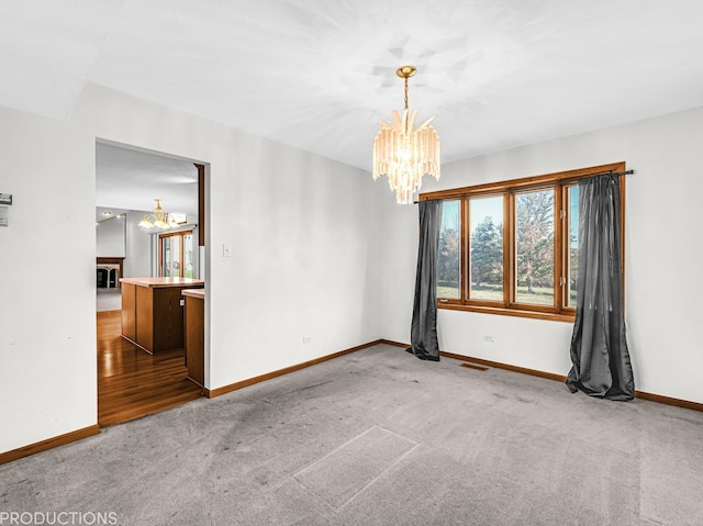 empty room featuring dark colored carpet and a notable chandelier