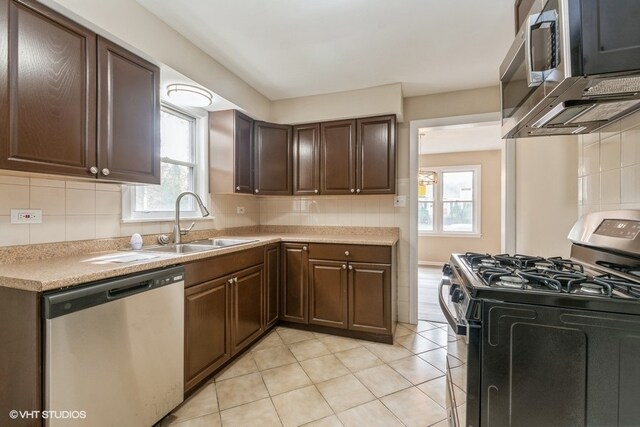 kitchen featuring decorative backsplash, dark brown cabinetry, stainless steel appliances, and sink