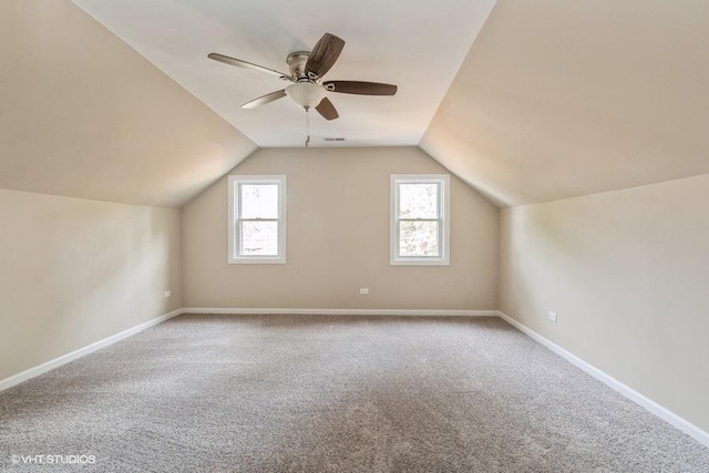 additional living space featuring baseboards, vaulted ceiling, carpet flooring, and a ceiling fan