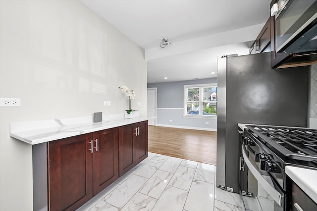 kitchen featuring light hardwood / wood-style floors, appliances with stainless steel finishes, and light stone counters