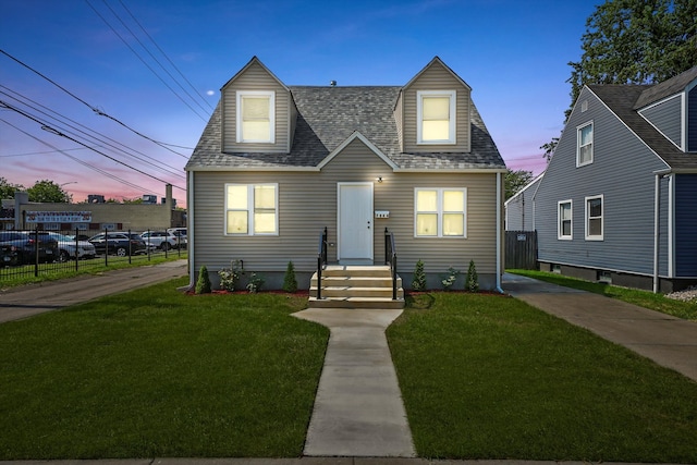 cape cod-style house featuring a lawn