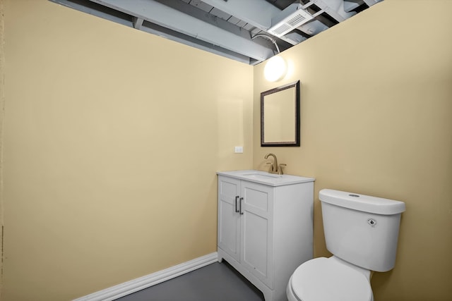 bathroom with vanity, concrete flooring, and toilet