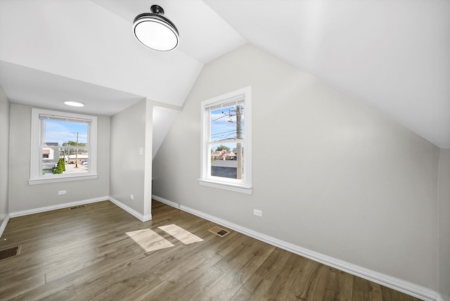 additional living space featuring lofted ceiling and dark hardwood / wood-style floors