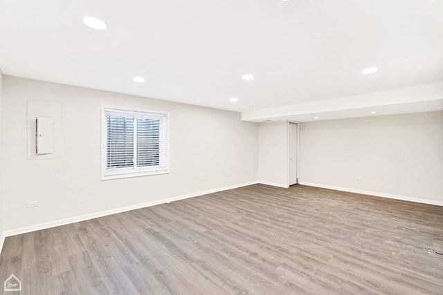 basement with electric panel and light wood-type flooring