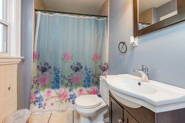 bathroom featuring vanity, toilet, tile patterned floors, and tile walls