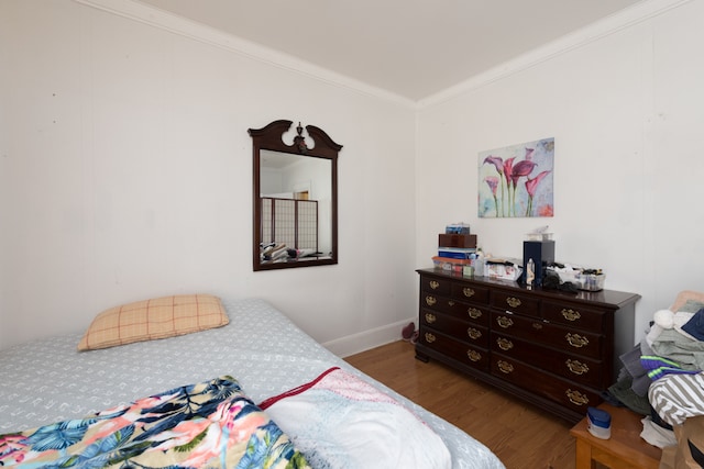 bedroom featuring ornamental molding and dark hardwood / wood-style flooring