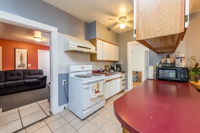 kitchen featuring premium range hood, white cabinetry, white gas stove, and tasteful backsplash