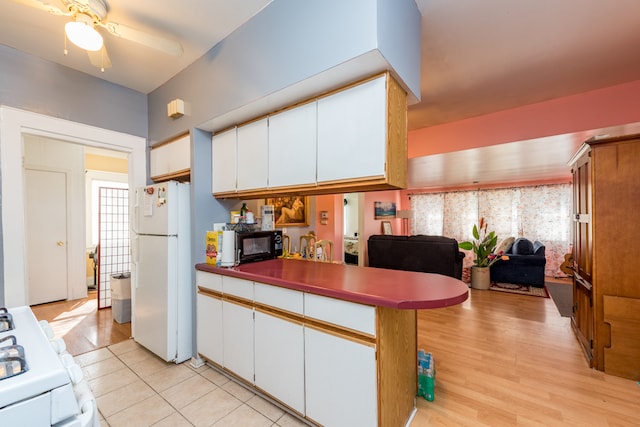 kitchen with light hardwood / wood-style floors, white cabinetry, and white appliances