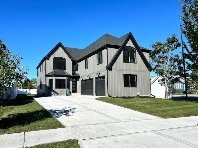 modern inspired farmhouse featuring a front lawn and a garage