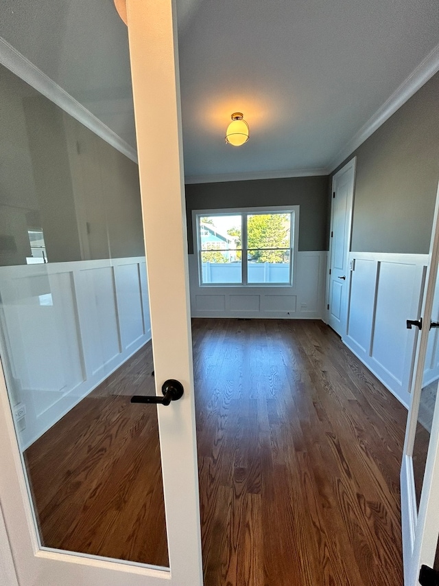 empty room with crown molding and dark hardwood / wood-style flooring