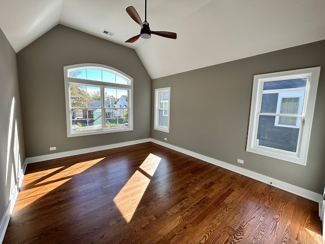 empty room with ceiling fan, vaulted ceiling, and dark hardwood / wood-style flooring