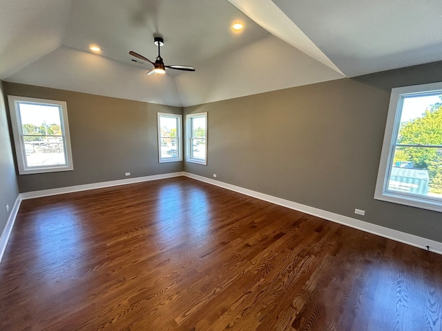 empty room with dark wood-type flooring, ceiling fan, and lofted ceiling