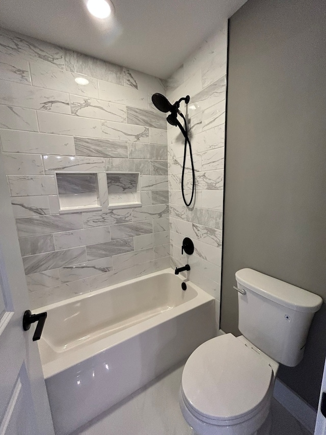 bathroom featuring tiled shower / bath and toilet