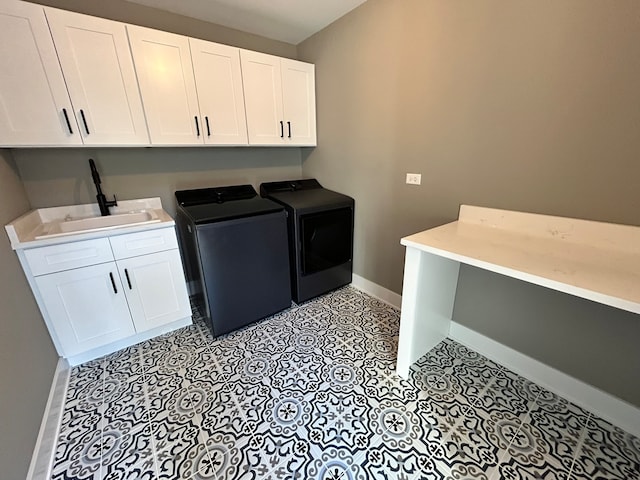 clothes washing area with cabinets, light tile patterned flooring, sink, and separate washer and dryer