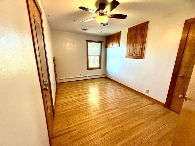 unfurnished room featuring ceiling fan, a baseboard radiator, and light wood-type flooring