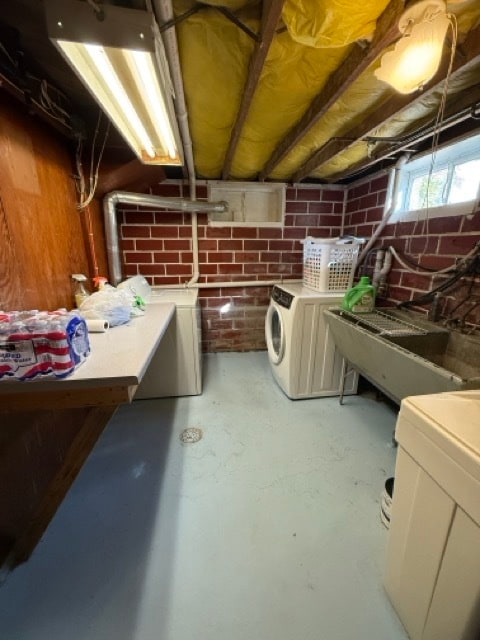 basement with brick wall and washer and dryer