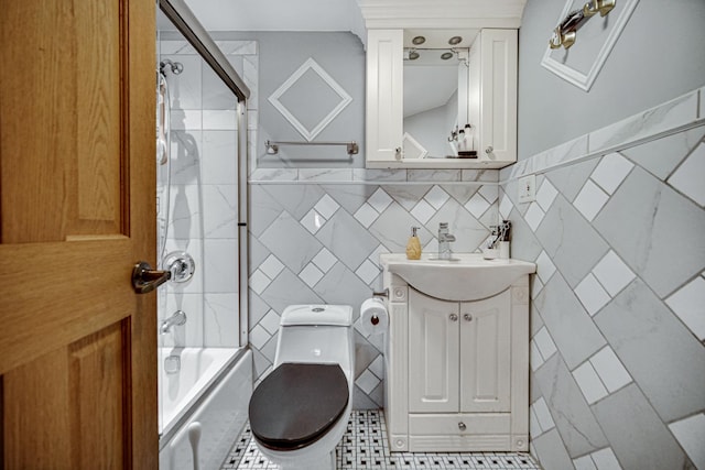 full bathroom with tiled shower / bath combo, tile patterned floors, vanity, tile walls, and toilet