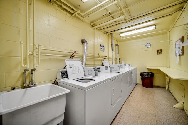 clothes washing area with separate washer and dryer and sink