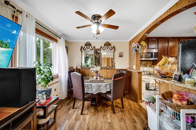 dining room featuring light wood-type flooring, ceiling fan, and crown molding