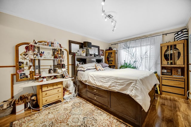 bedroom with hardwood / wood-style floors and ornamental molding