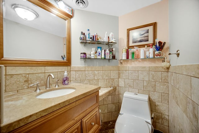 bathroom featuring toilet, vanity, and tile walls