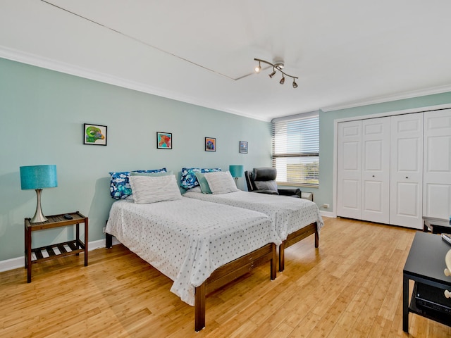 bedroom with a closet, crown molding, and light wood-type flooring