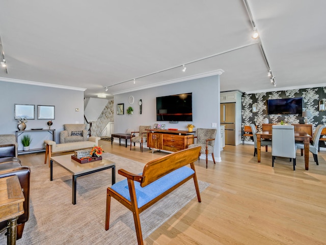 living room featuring rail lighting, crown molding, and light wood-type flooring