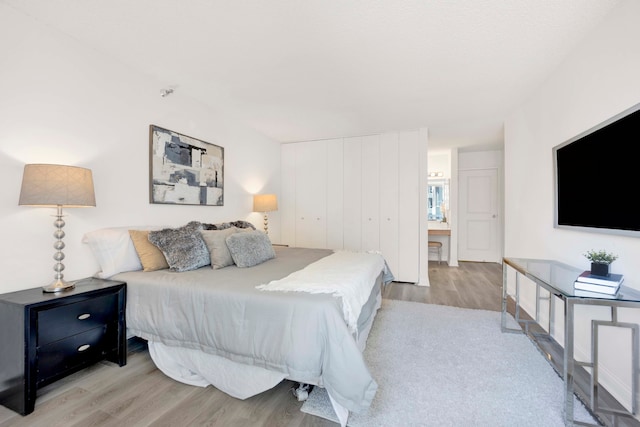 bedroom with light hardwood / wood-style flooring and a closet