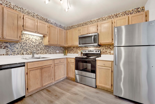 kitchen with appliances with stainless steel finishes, light hardwood / wood-style flooring, sink, and light brown cabinets