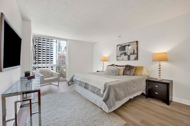 bedroom with a textured ceiling and light wood-type flooring