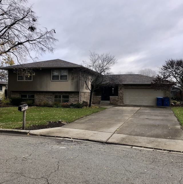 tri-level home with an attached garage, driveway, and a front lawn